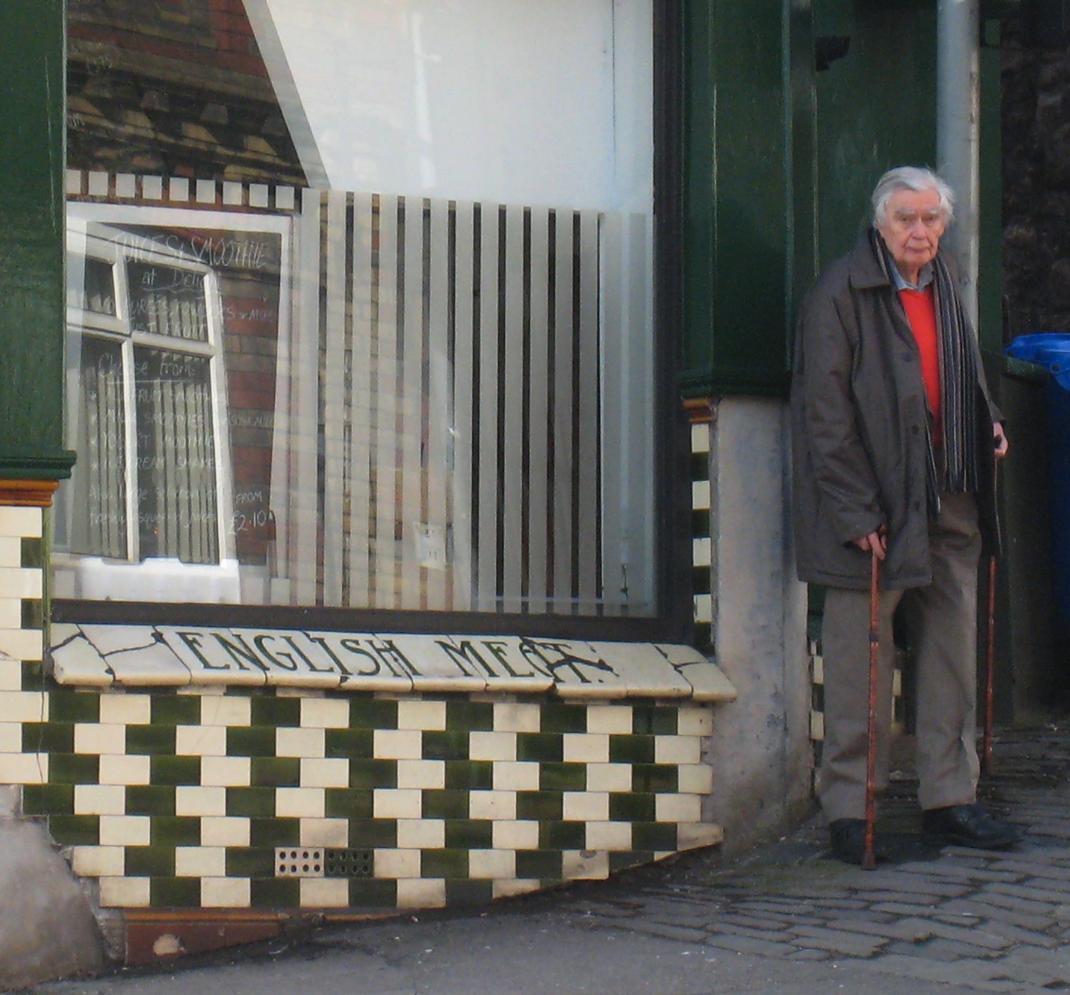 Richard Gregory stands beside the alternating black-and-white tiles of the café wall associated with the illusion.