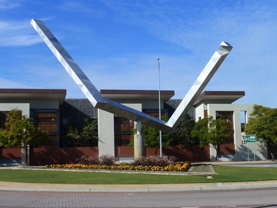 A side viewpoint of the triangle sculpture shows an open, bent arrangement of metal beams.